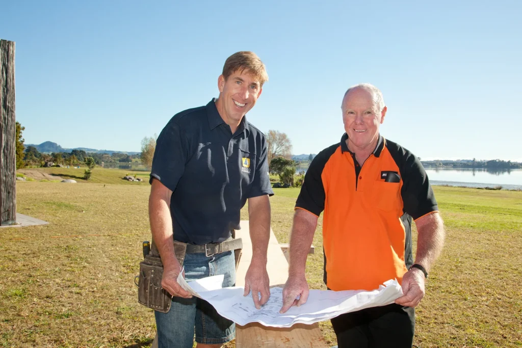 Mike Bell of Belco Homes going over house plans with Dave Ashton from Mitre 10 Waihi in 2012